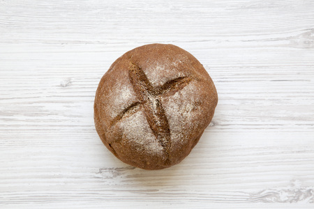 Freshly baked bread on white wooden table, top view