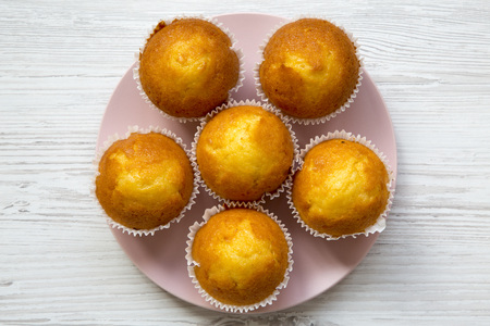 Top view of fresh tasty muffins on pink plate over white wooden background.の写真素材