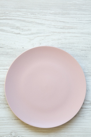 Empty pink plate on white wooden surface. Top view, from above, flat lay. Dieting concept.の写真素材