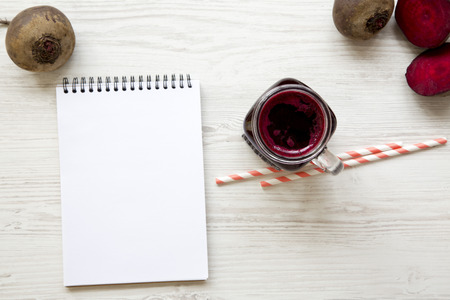 Beetroot juice in glass jar and blank notepad. Top view.の写真素材