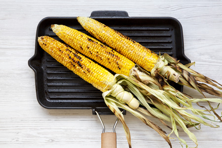 Grilled corn on the cob in a grilling pan, top view.