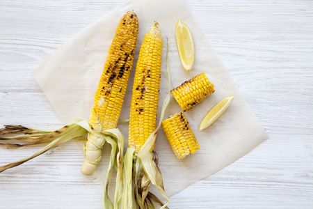 Grilled corn on the cob with slices of lemon, close-up. Summer food. Top view, from above, overhead.