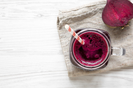 Beetroot smoothie in glass jar mug over white wooden background, view from above. Flat lay, overhead. Copy space and text area.の写真素材