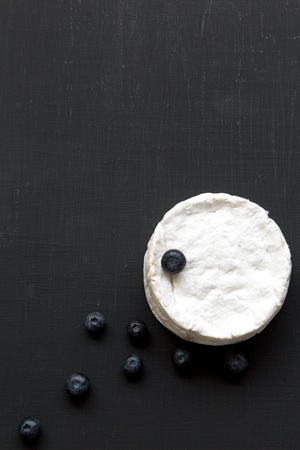Camembert cheese or brie on black background. Flatlay, closeup. Top view. Copy space.の写真素材