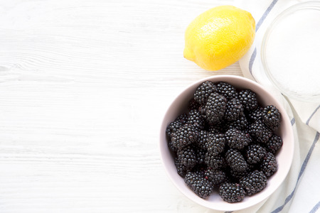 Ingredients for blackberries jam with copy space. White wooden table. From above, overhead.の写真素材