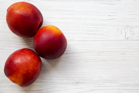 Nectarines on a white wooden background, top view. Closeup. Copy space.