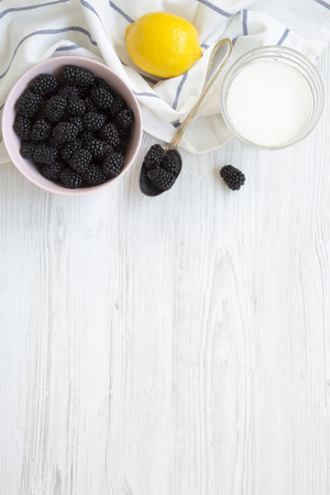 Ingredients for blackberries jam: berries, lemon, sugar on a white wooden background. From above, overhead. Space for text.の写真素材