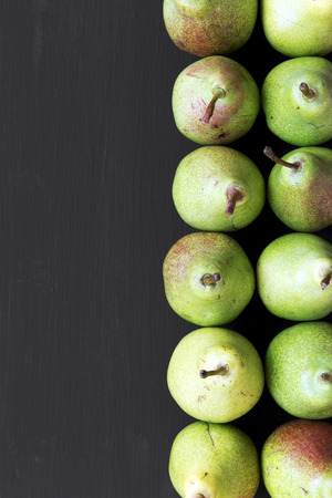 Fresh pears on black background, overhead view. From above, flat lay. Copy space.の写真素材
