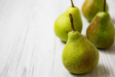 Fresh pears on a white wooden surface, side view. Closeup. Space for text.の写真素材