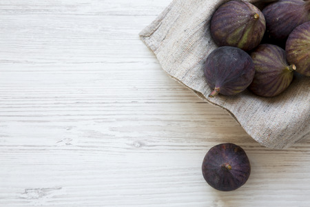 Top view fresh figs in a bowl on a white wooden background. Flat lay, overhead, from above. Copy space.の写真素材