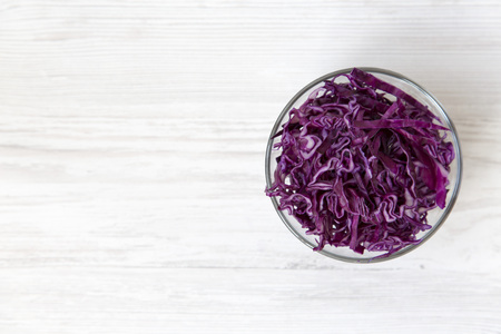 Chopped red cabbage in a bowl, close-up. Top view, from above, overhead. Copy space.