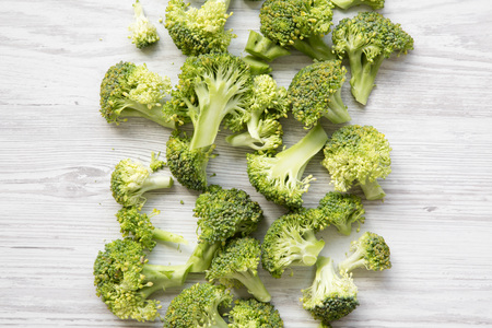Freshly cut raw broccoli on white wooden surface, overhead view. Flat lay, from above.の写真素材
