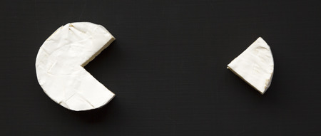 Cheese camembert or brie on black background. Milk production. Overhead view. Food for wine.