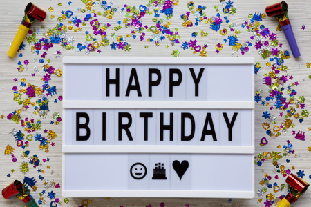 Modern board with text 'Happy Birthday', decoration party on white wooden background, overhead view. Flat lay, top view, from above.の写真素材