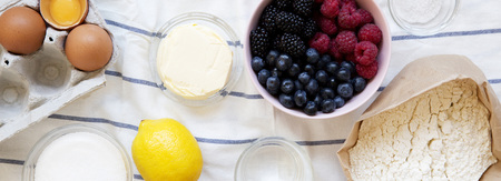 Raw ingredients: berries, flour, eggs, butter, lemon, water, sugar, salt for cooking berry pie on...