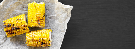 Grilled corn on the cob over black background, overhead view. Summer food. From above, flat lay. Space for text.の写真素材