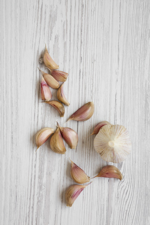 Garlic on white wooden background, overhead view. From above, flat lay. Copy space.の写真素材