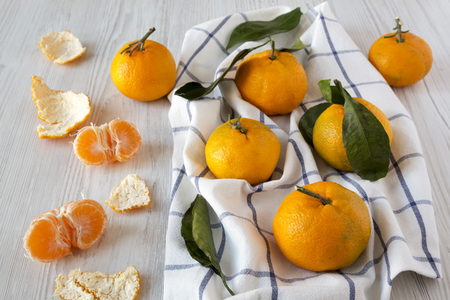 Fresh ripe tangerines on a white wooden background, side view.