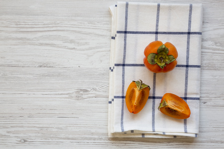 Fresh persimmon over white wooden background, overhead view. Copy space.の写真素材