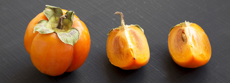 Fresh persimmon on black background, side view. Closeup.の写真素材