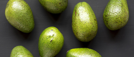 Whole avocados on black background, top view. Overhead, from above, flat lay.の写真素材