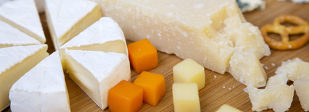 Tasting cheese with pretzels on bamboo board, side view. Food for wine. Close-up.の写真素材
