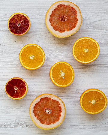 Citrus fruits (orange, grapefruit, sicilian orange) on white wooden background, from above. Flat lay. Top view, overhead.の写真素材