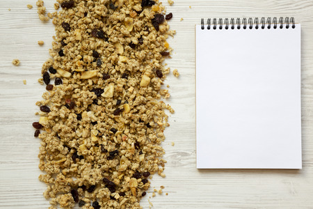 Fruit granola and blank notepad on white wooden background, top view. Overhead, from above.の写真素材