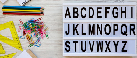 Back to school concept. Letters from A to Z. English alphabet on modern board and accessories for...