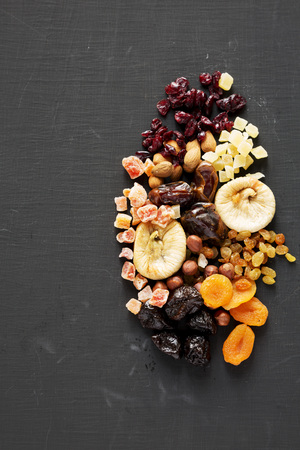 Dried fruits and nut mix on black surface, top view. Overhead. Copy space.の写真素材