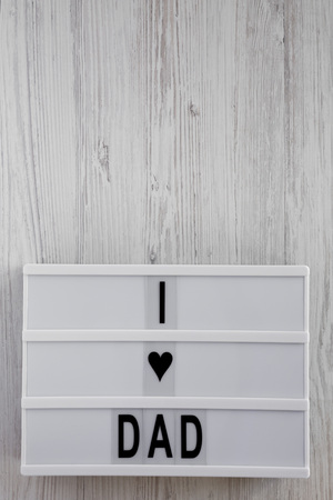 Modern board with 'I love dad' words over white wooden background, top view. Overhead, from above, flat lay. Father's day. Copy space.の写真素材
