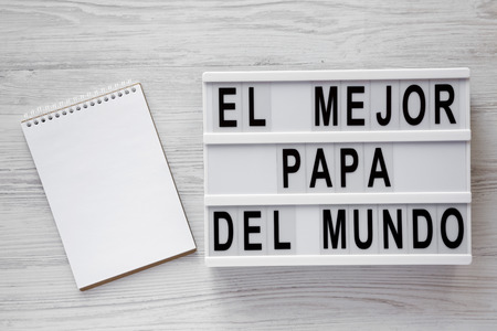 'El Mejor Papa Del Mundo' words on modern board, blank notepad over white wooden background, top view. Overhead, from above, flat lay. Father's day concept.の写真素材