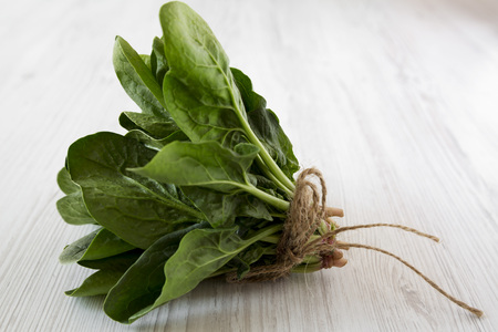 Fresh raw spinach on a white wooden surface, side view. Close-up.の写真素材