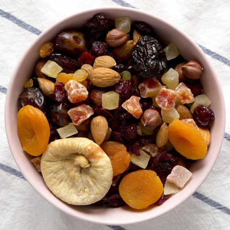 Dried fruits and nuts in a pink bowl, view from above. Overhead, flat lay, top view.の写真素材