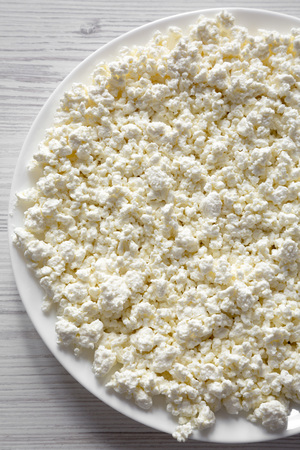 Homemade cottage cheese on a white plate, top view. Flat lay, overhead, from above. Close-up.の写真素材