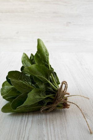 Fresh raw spinach on a white wooden background, side view. Close-up.の写真素材