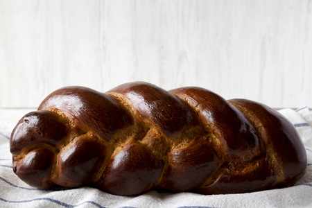Homemade jewish challah bread on a white wooden background, side view. Closeup.の写真素材