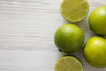 Green citrus limes on a white wooden background, top view. From above, overhead, flat lay. Copy space.の写真素材