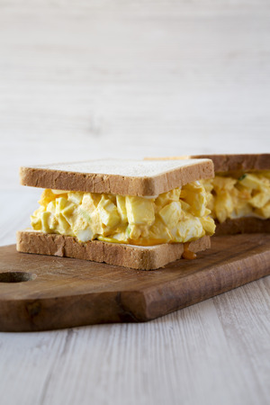 Homemade egg salad sandwich on a rustic wooden board, side view. Close-up.の写真素材