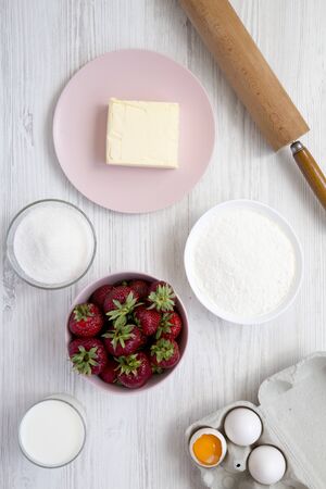 Strawberry pie ingredients (flour, eggs, butter, milk, sugar, strawberry), top view. Cooking strawberry pie or cake.の写真素材