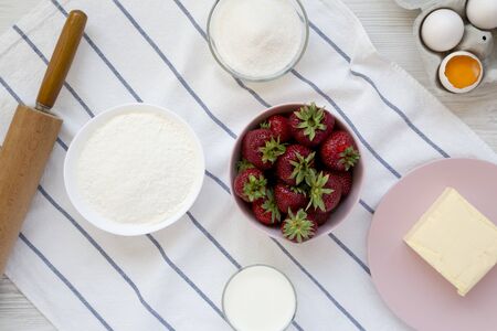Strawberry pie ingredients (flour, eggs, butter, milk, sugar, strawberry), top view. Cooking strawberry pie or cake. Flat lay, overhead, from above. Close-up.の写真素材