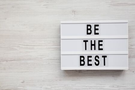'Be the best' words on a lightbox on a white wooden background. Flat lay, overhead, top view. Copy space.の写真素材