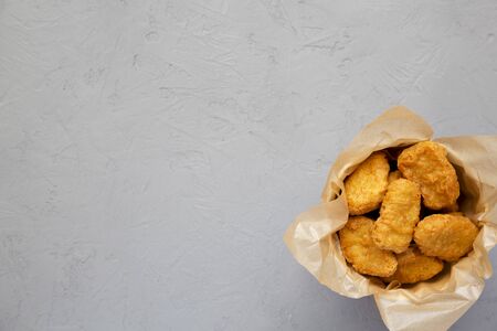 Chicken nuggets in a paper box, ketchup on a concrete background. Overhead, from above, flat lay. Copy space.の写真素材