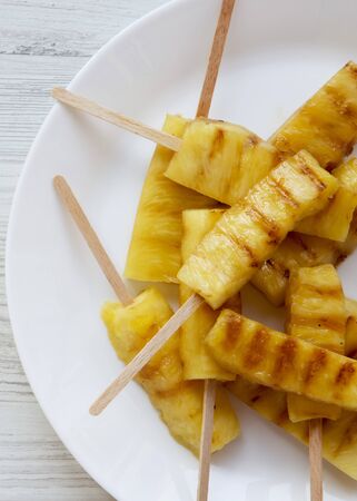 Grilled pineapple on bamboo sticks, top view. From above, flat lay, overhead. Close-up.の写真素材