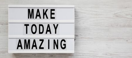 'Make today amazing' words on a lightbox on a white wooden surface. From above, overhead, flat lay, top view. Space for text.の写真素材