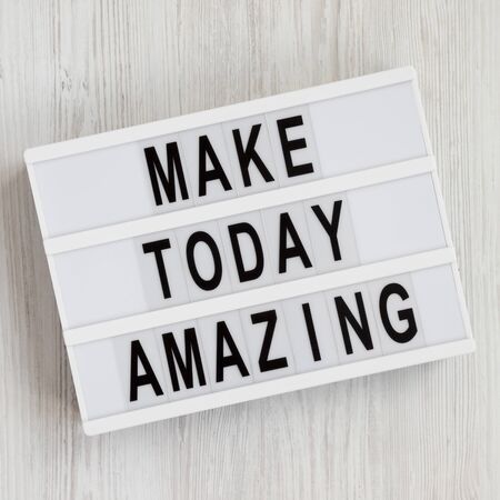 'Make today amazing' words on a lightbox on a white wooden background. From above, overhead, flat lay, top view. Close-up.の写真素材