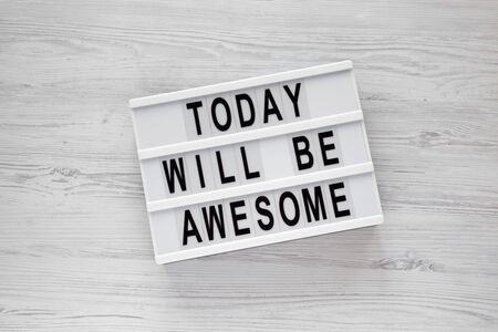 'Today will be awesome' words on a lightbox over white wooden background, overhead view. Flat lay, from above, top view.の写真素材