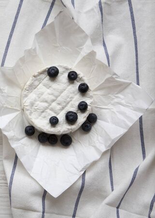 Camembert cheese in paper, top view. Food for wine.の写真素材