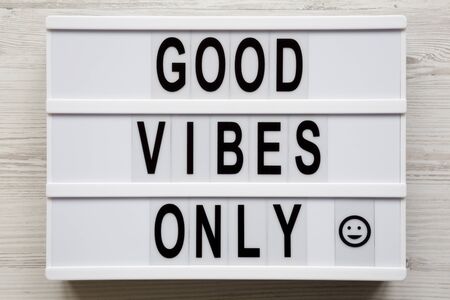 Overhead view, 'Good vibes only' words on a lightbox on a white wooden background, top view. From above, overhead, flat lay.の写真素材
