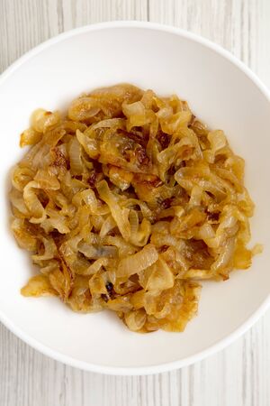 Homemade caramelized onions on a white plate, top view. Flat lay, overhead, from above. Close-up.の写真素材